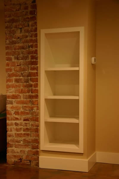 Milks Project: Custom in-wall bookshelf doubles as a laundry chute on the opposing side